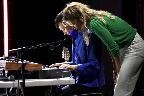 Un homme joue du piano et une femme, adossée à son épaule, semble chanter.