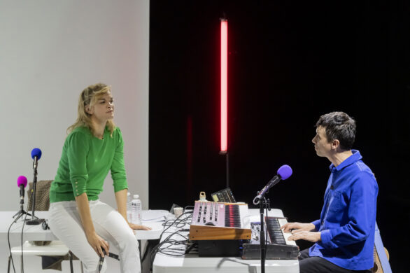 Un homme joue du piano et face à lui, une femme chante, assise sur une tablee cha