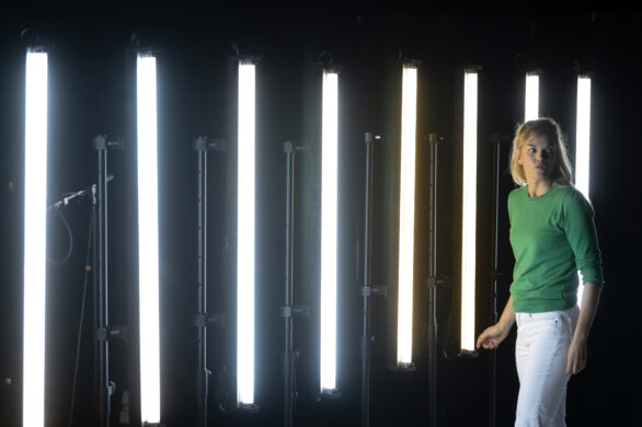 Une femme à droite de l'image, devant des néons LED